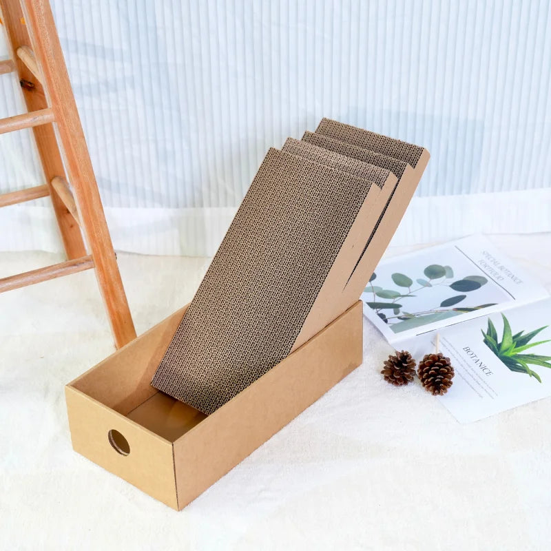 Angled cardboard cat scratcher box on a white floor with small toy balls nearby